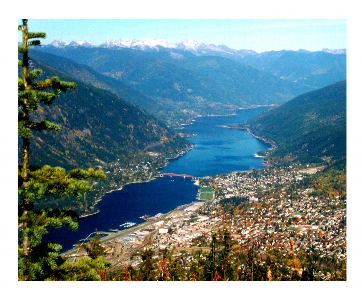 view of a city (Nelson BC) and a river in a valley with snowcapped mountains nearby