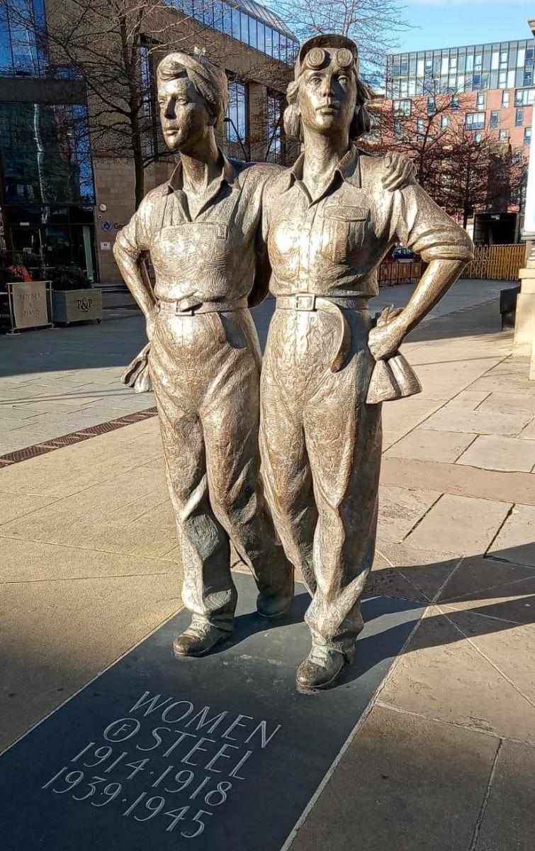 statue of 2 women in coveralls, with plaque "women of steel 1914-1918 1939-1945"