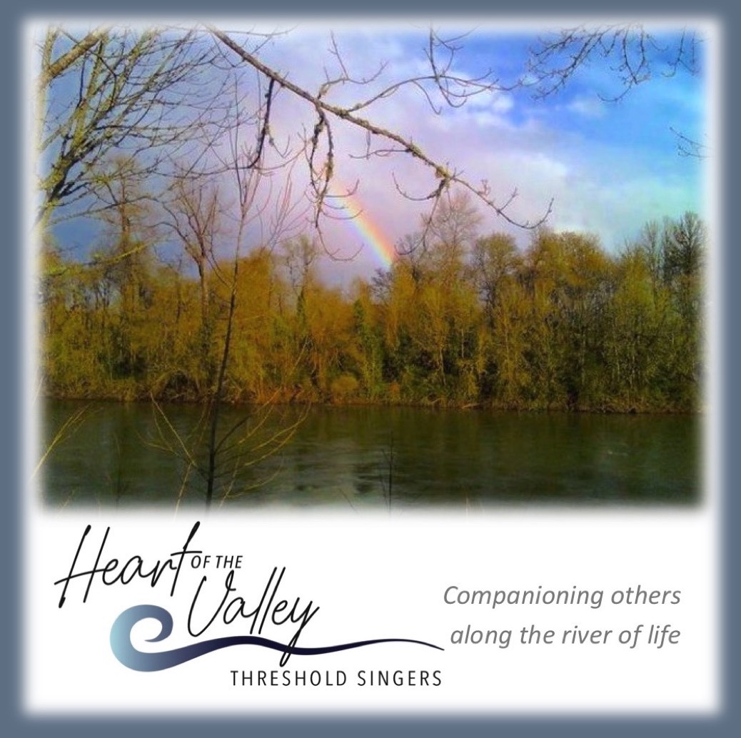 photo looking across river at trees on the other bank; part of a rainbow appears behind the trees. There is a branch in the foreground. At the bottom left of the image is "Heart of the Valley THRESHOLD SINGERS" with a gray furl below "Valley". On the bottom right it says "Companioning others along the river of life". The background of the image is white. It is surrounded with a gray "fade" border.