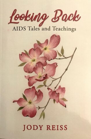 Book cover. Looking Back: AIDS Tales and Teachings. Jody Reiss. Picture of pink dogwood branch on cream background.