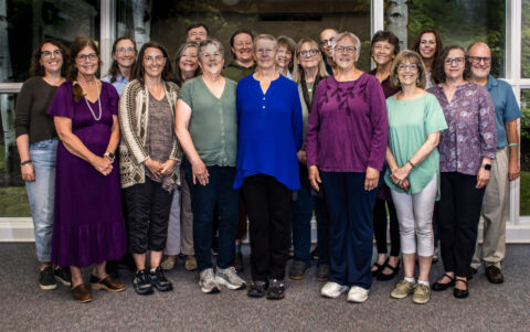 group of smiling men and women, standing